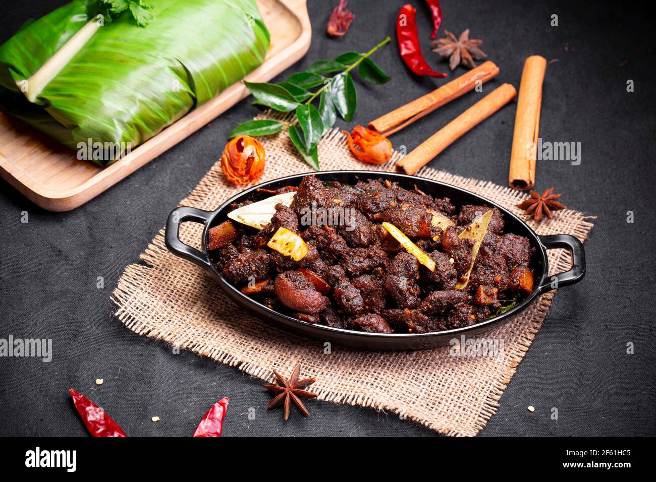 Beef roast or  pothu ulartheyadu, kerala special dish arranged in an black table ware and in banana leaf  in traditional way placed  on a black colour Stock Photo