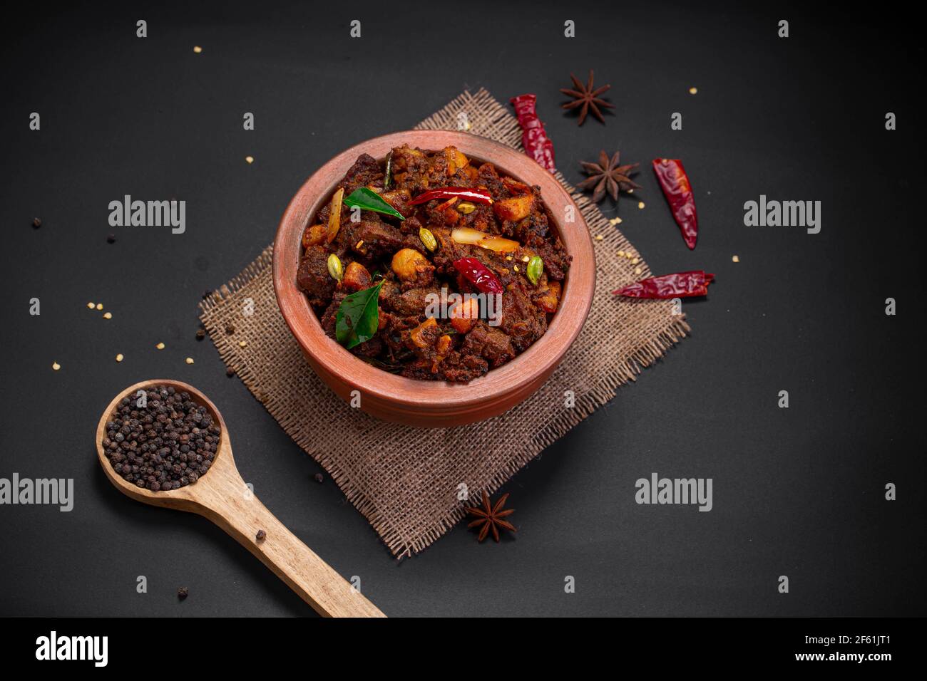 Beef roast or  pothu ulartheyadu, kerala special dish arranged in an earthenware in traditional way garnished with coconut pieces. Stock Photo