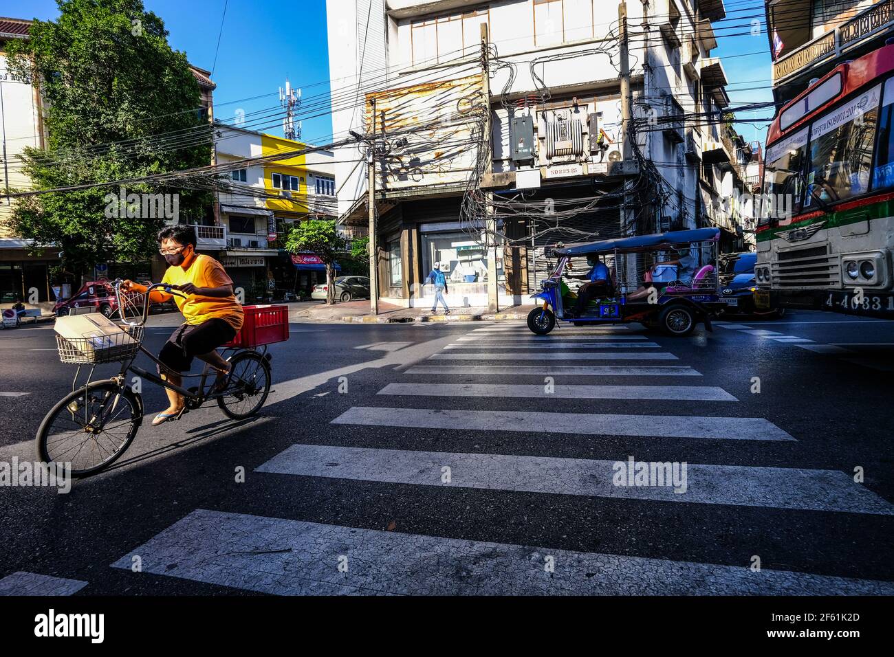 An elderly woman cycles across a pedestrian crossing in Talat Noi ...