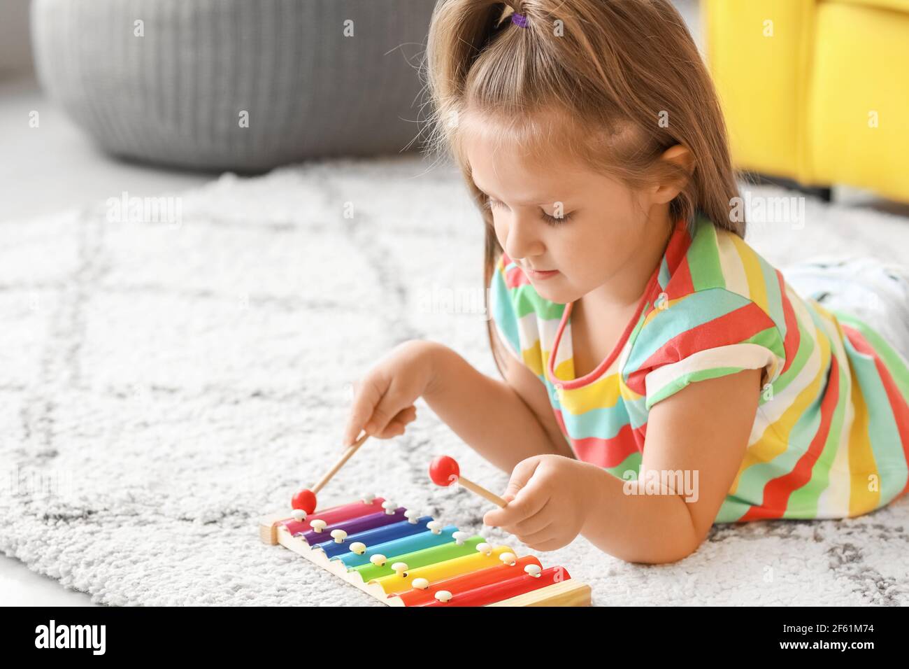 Cute little girl with xylophone at home Stock Photo Alamy