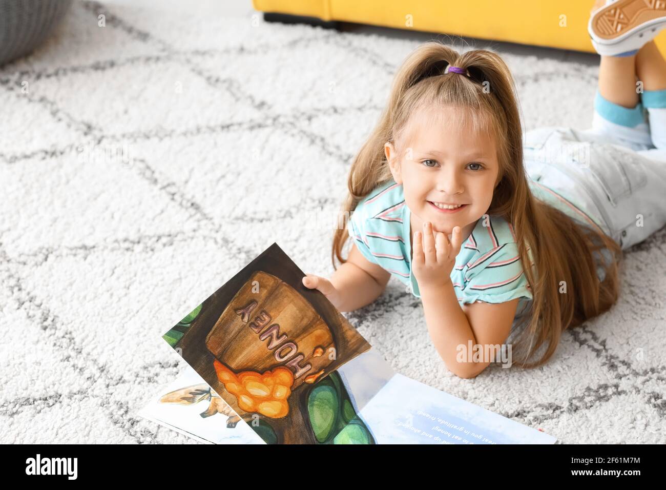 Cute little girl reading book at home Stock Photo - Alamy