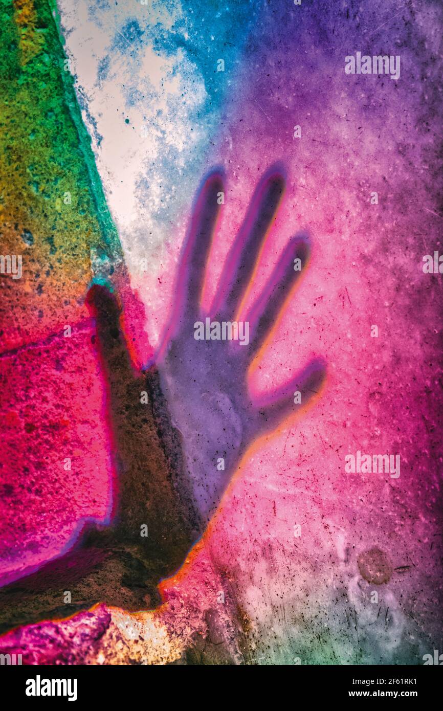 Silhouette of hand against colourful background. Stock Photo