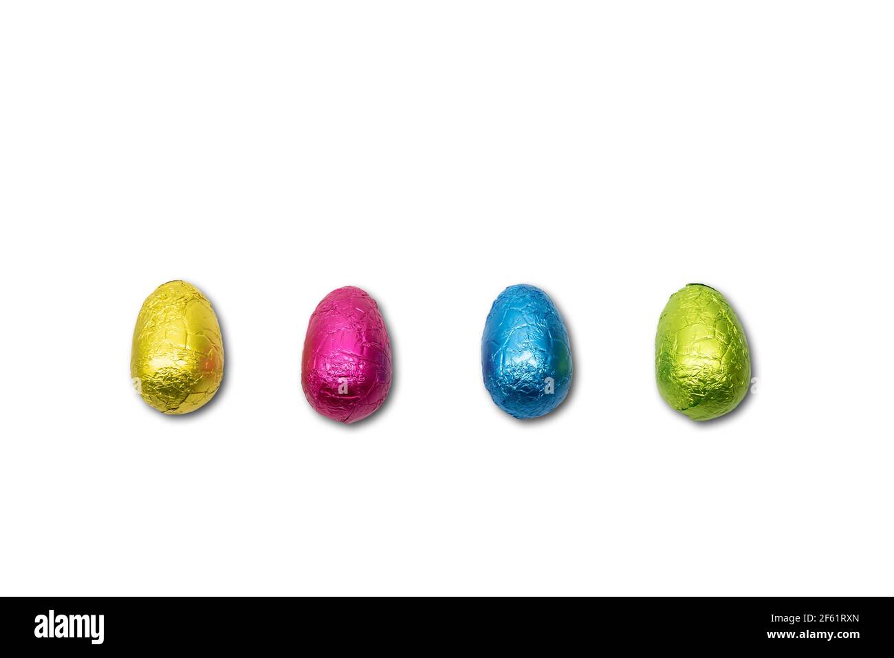 Four wrapped chocolate Easter eggs on white. Stock Photo