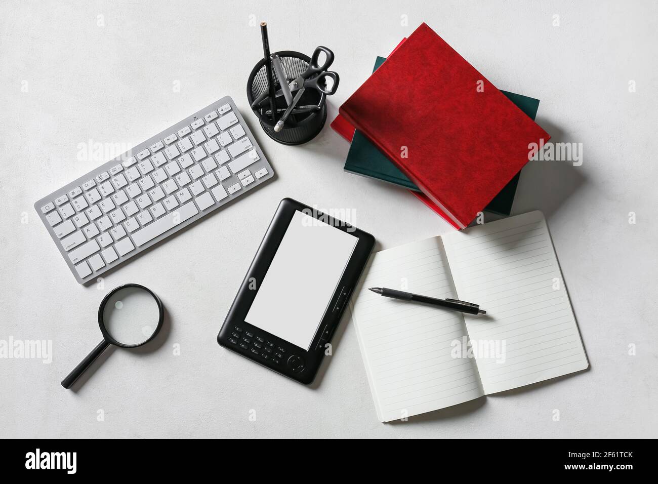 Composition with e-reader, computer keyboard and stationery on light background Stock Photo