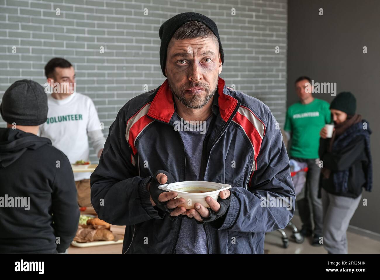 Poor homeless man with hot food in warming center Stock Photo - Alamy