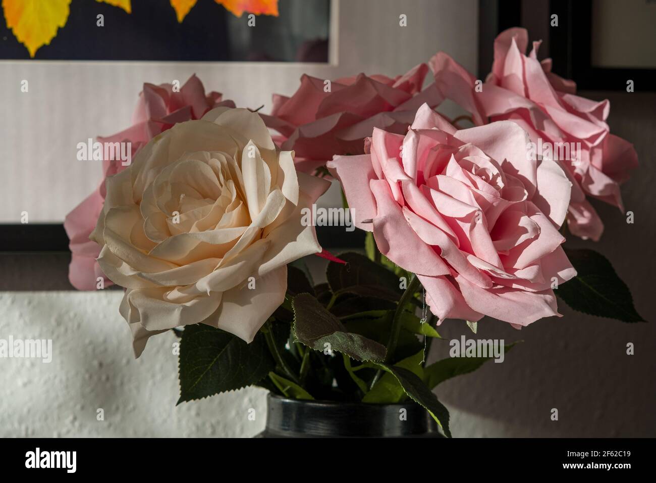 Closeup with huge, different fake rose flowers in a vase Stock Photo