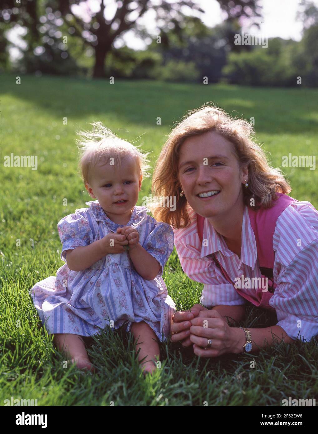 Mother and daughter lying in garden, Winkfield, Berkshire, England, United Kingdom Stock Photo