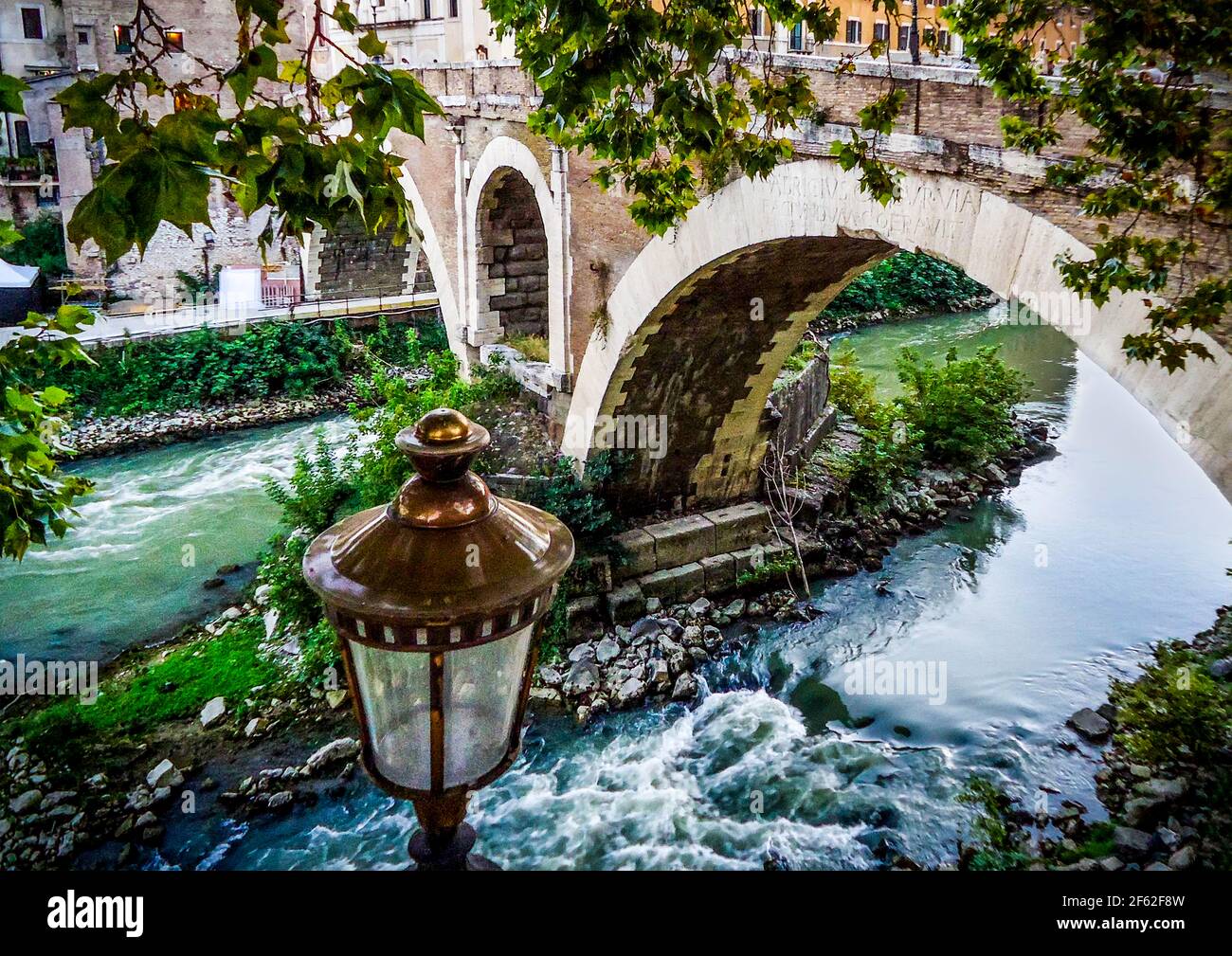 Pictoresque capture of a river flowing down an old stone bridge Stock Photo