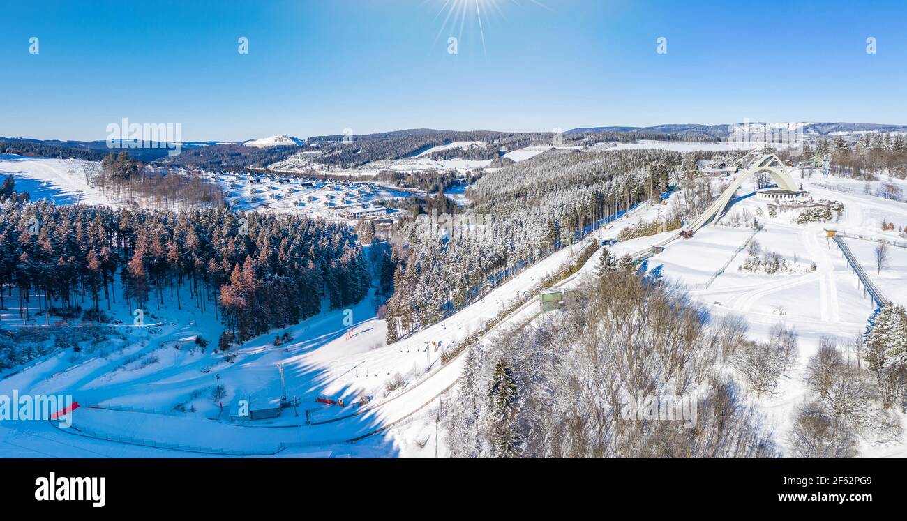 Saint George ski jump and ski slopes of Winterberg ski lift carousel photographed from the air. Panorama image of deserted winter sports area. Stock Photo