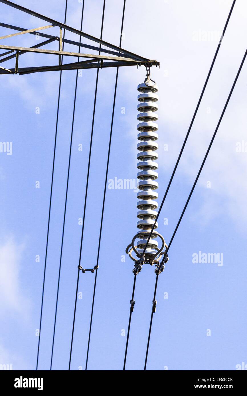 A cap and pin insulator string on a pylon carrying high voltage cables across the Cotswolds, Gloucestershire UK Stock Photo