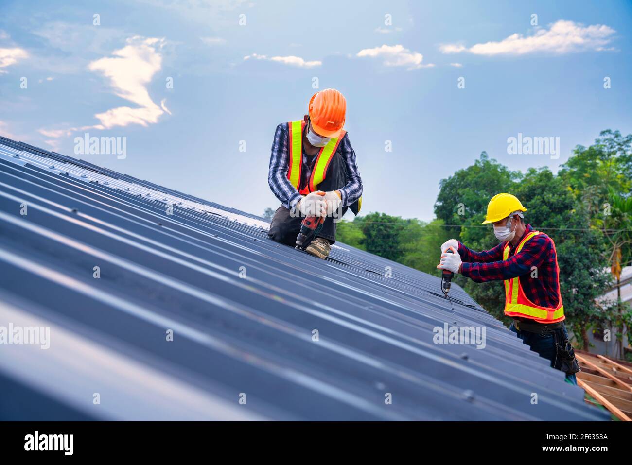Team work Roof concept of residential building under construction, Roofer  worker safety wear using air or pneumatic nail gun and installing on new  roo Stock Photo - Alamy