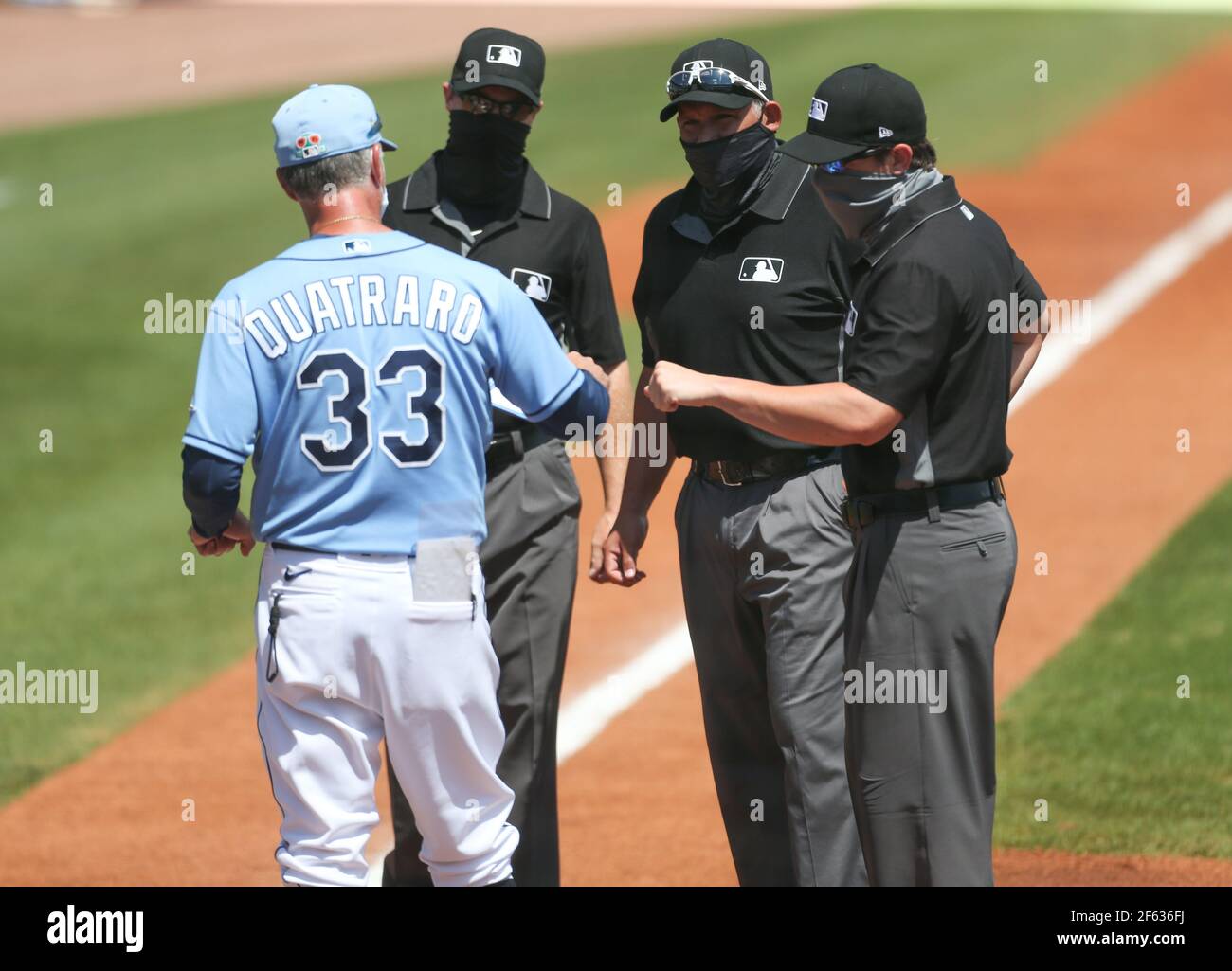 Sunday, March 28, 2021 Port Charlotte: Tampa Bay Rays coach Matt Quatraro fist bumps with the umpire crew during a spring training baseball game at the Charlotte Sports Park. The Rays beat the Braves 16-5 in nine innings. (Kim Hukari/Image of Sport) Stock Photo