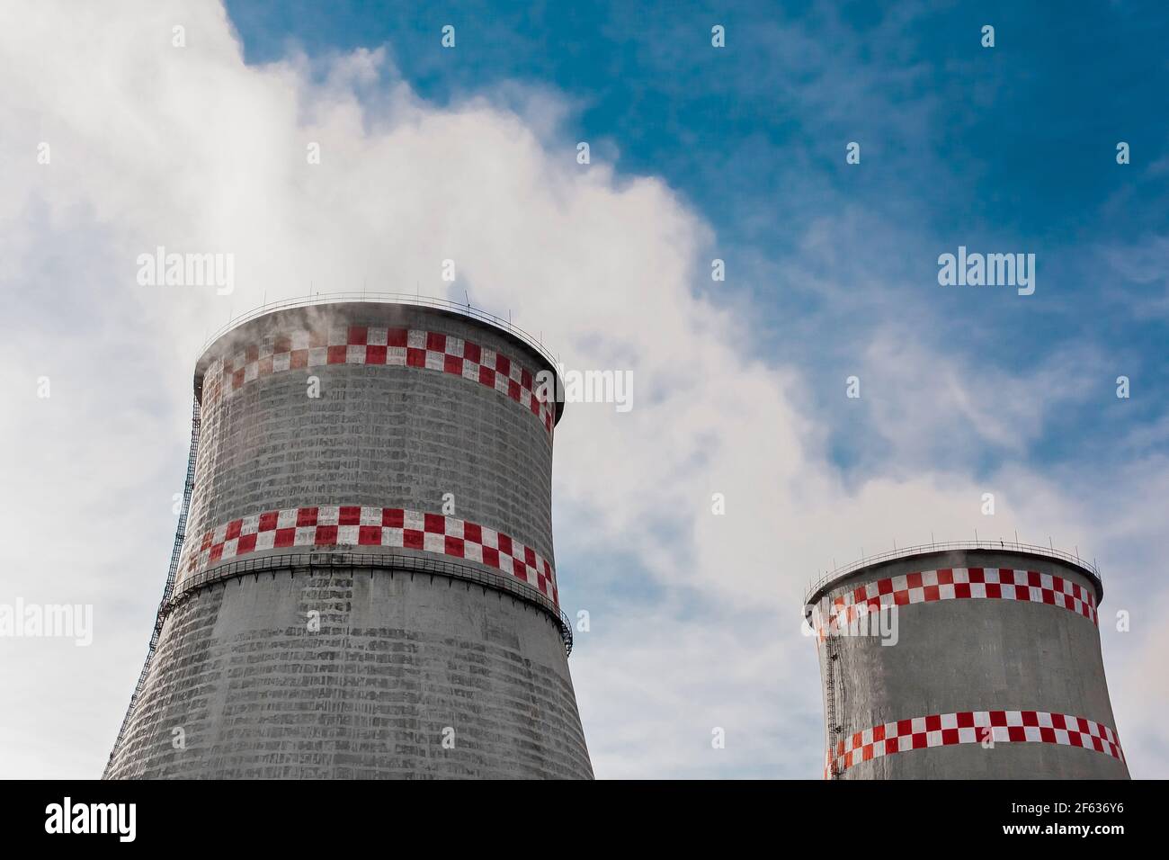 Cooling tower of an industrial plant or thermal power plant against a blue sky. Stock Photo