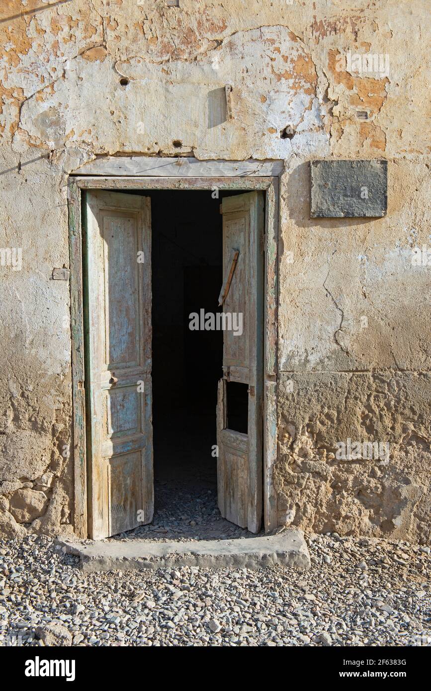 Old rustic wooden door in wall of abandoned traditional egyptian house Stock Photo