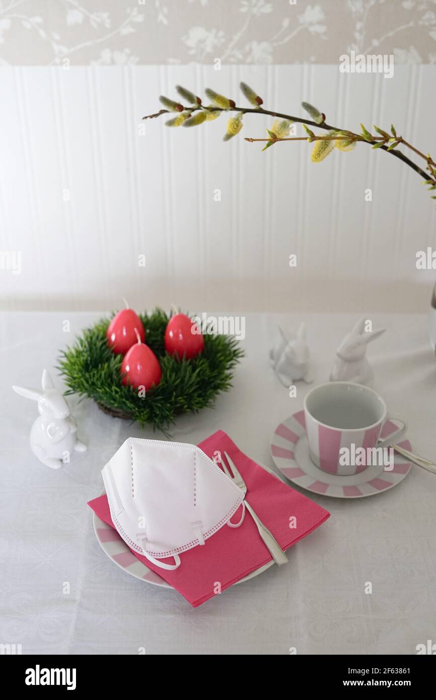 Easter holiday coffee table scene with face mask on plate Stock Photo