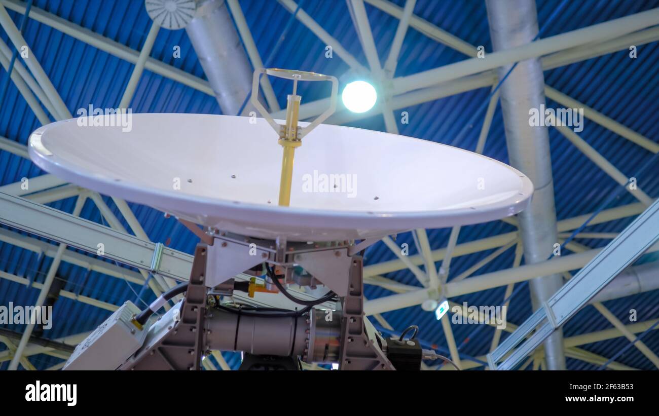 White rotating satellite dish antenna using to receive or transmit information Stock Photo