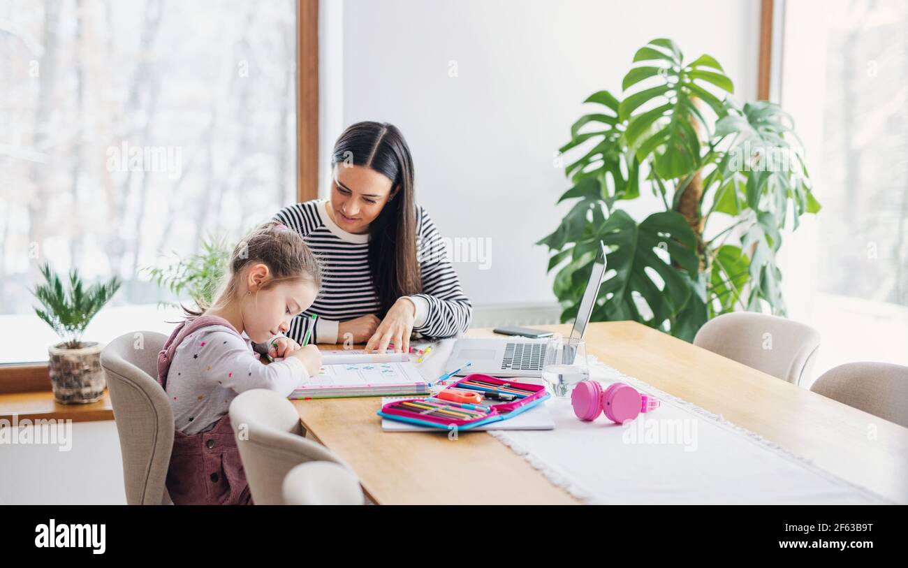 Mother with school girl indoors at home, distance learning and home ...