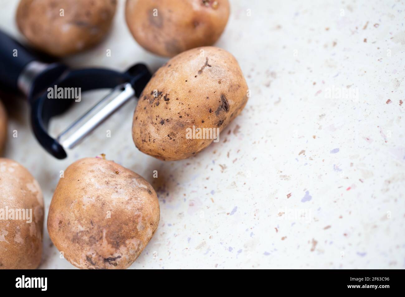 https://c8.alamy.com/comp/2F63C96/several-organic-potatoes-and-a-potato-peeler-on-the-table-made-in-natural-light-soft-shadows-2F63C96.jpg