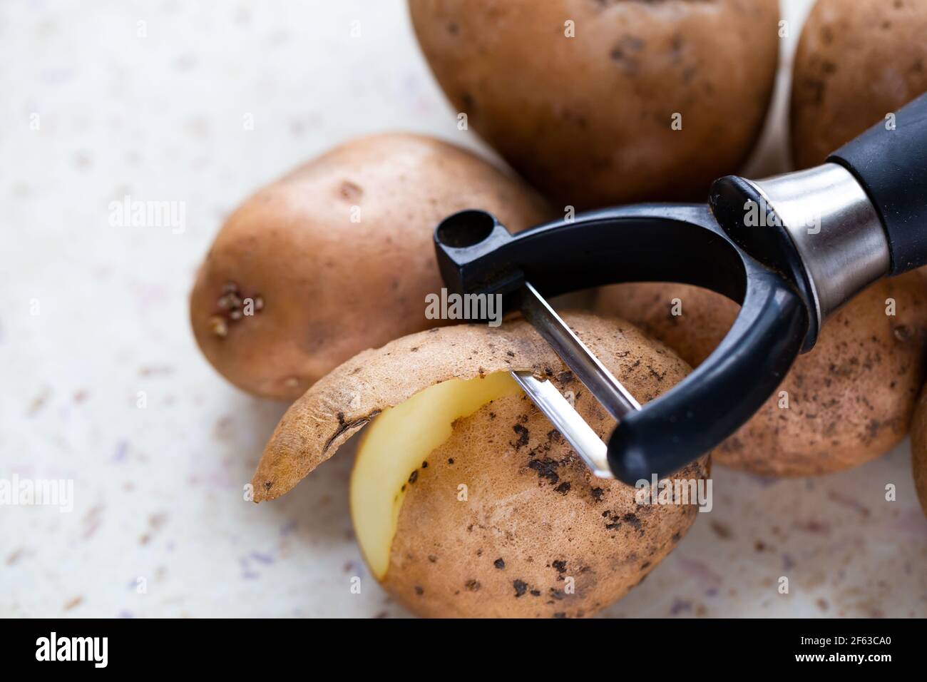 https://c8.alamy.com/comp/2F63CA0/several-organic-potatoes-and-a-potato-peeler-on-the-table-made-in-natural-light-soft-shadows-2F63CA0.jpg