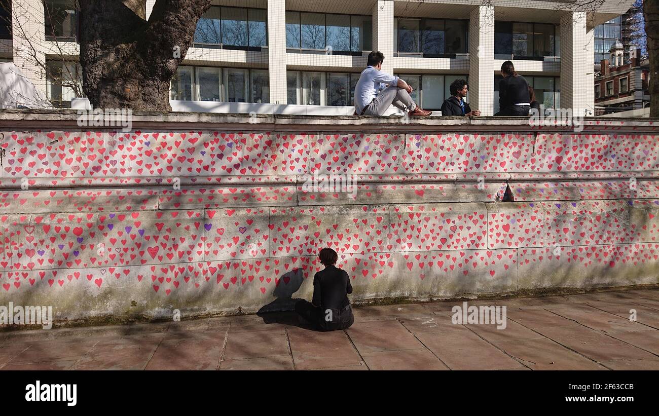 London, UK. 29th, March, 2021. Bereaved family and friends are visited by Keir Starmer as they paint hearts onto the Covid Memorial Wall. Stock Photo
