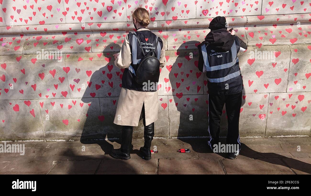 London, UK. 29th, March, 2021. Bereaved family and friends are visited by Keir Starmer as they paint hearts onto the Covid Memorial Wall. Stock Photo