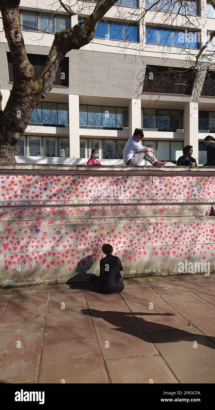 London, UK. 29th, March, 2021. Bereaved family and friends are visited by Keir Starmer as they paint hearts onto the Covid Memorial Wall. Stock Photo