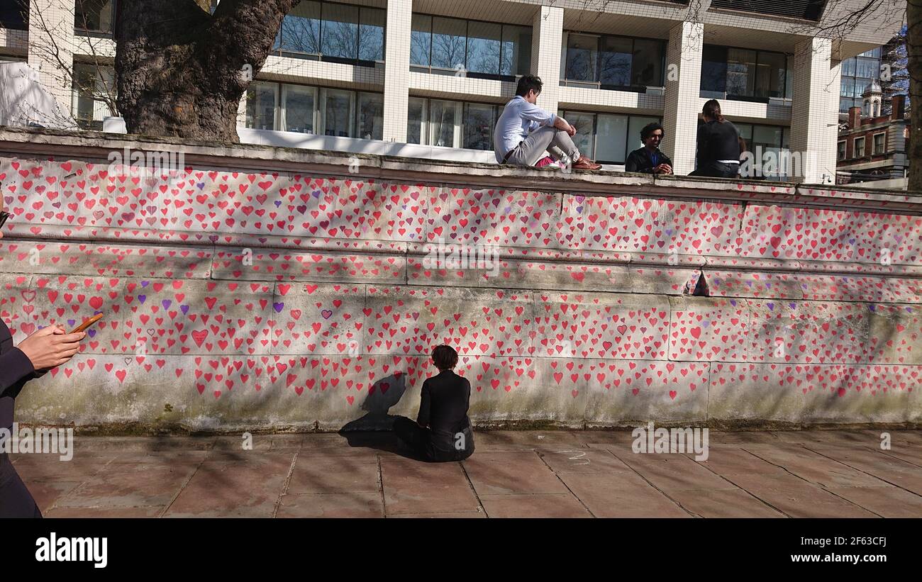 London, UK. 29th, March, 2021. Bereaved family and friends are visited by Keir Starmer as they paint hearts onto the Covid Memorial Wall. Stock Photo