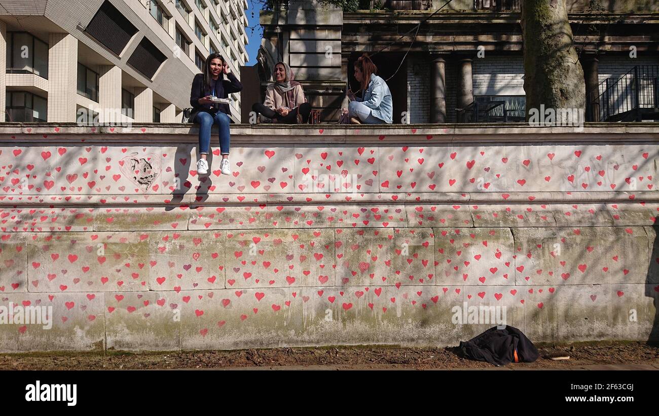 London, UK. 29th, March, 2021. Bereaved family and friends are visited by Keir Starmer as they paint hearts onto the Covid Memorial Wall. Stock Photo