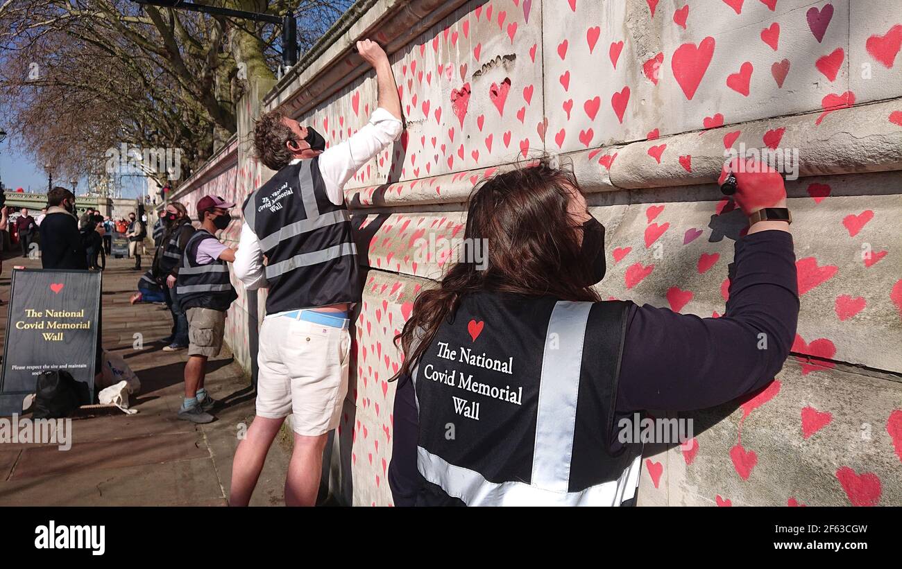 London, UK. 29th, March, 2021. Bereaved family and friends are visited by Keir Starmer as they paint hearts onto the Covid Memorial Wall. Stock Photo