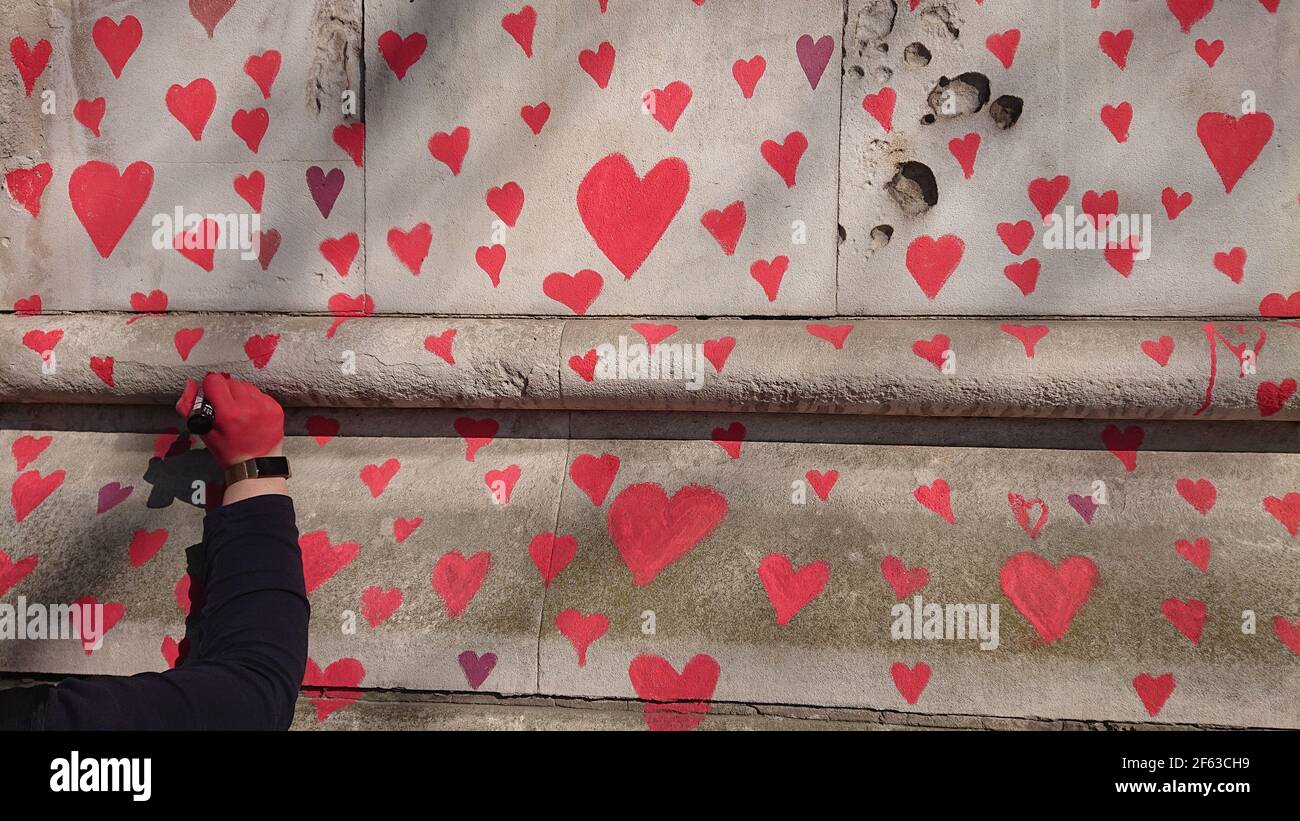 London, UK. 29th, March, 2021. Bereaved family and friends are visited by Keir Starmer as they paint hearts onto the Covid Memorial Wall. Stock Photo