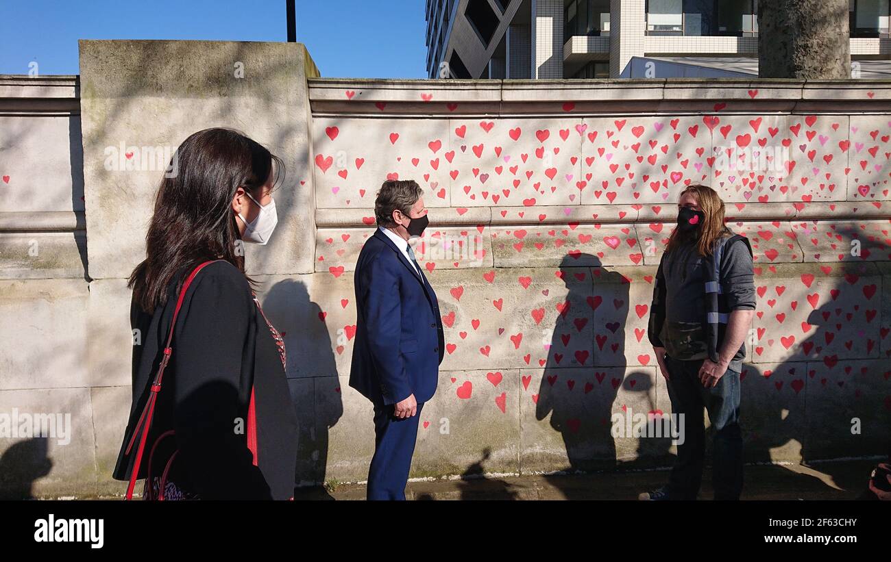 London, UK. 29th, March, 2021. Bereaved family and friends are visited by Keir Starmer as they paint hearts onto the Covid Memorial Wall. Stock Photo