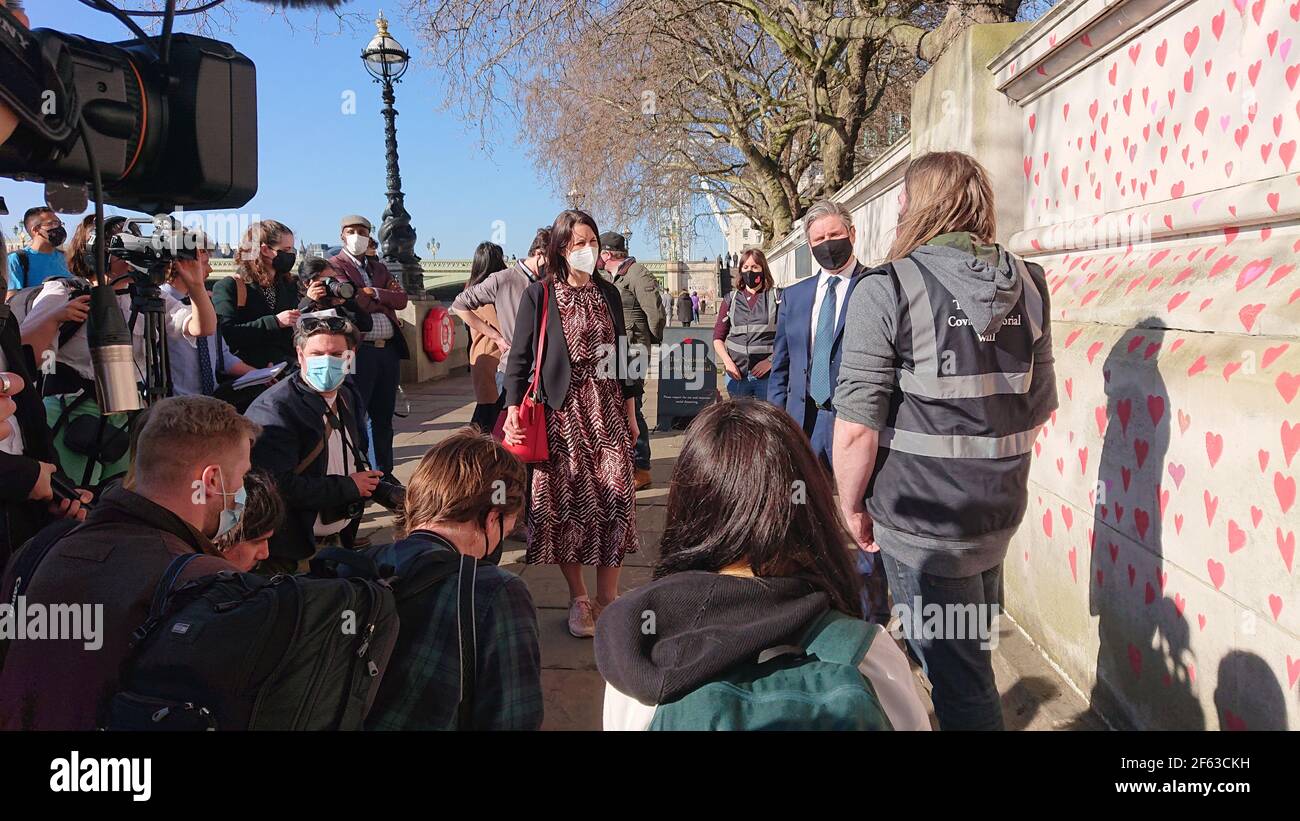 London, UK. 29th, March, 2021. Bereaved family and friends are visited by Keir Starmer as they paint hearts onto the Covid Memorial Wall. Stock Photo