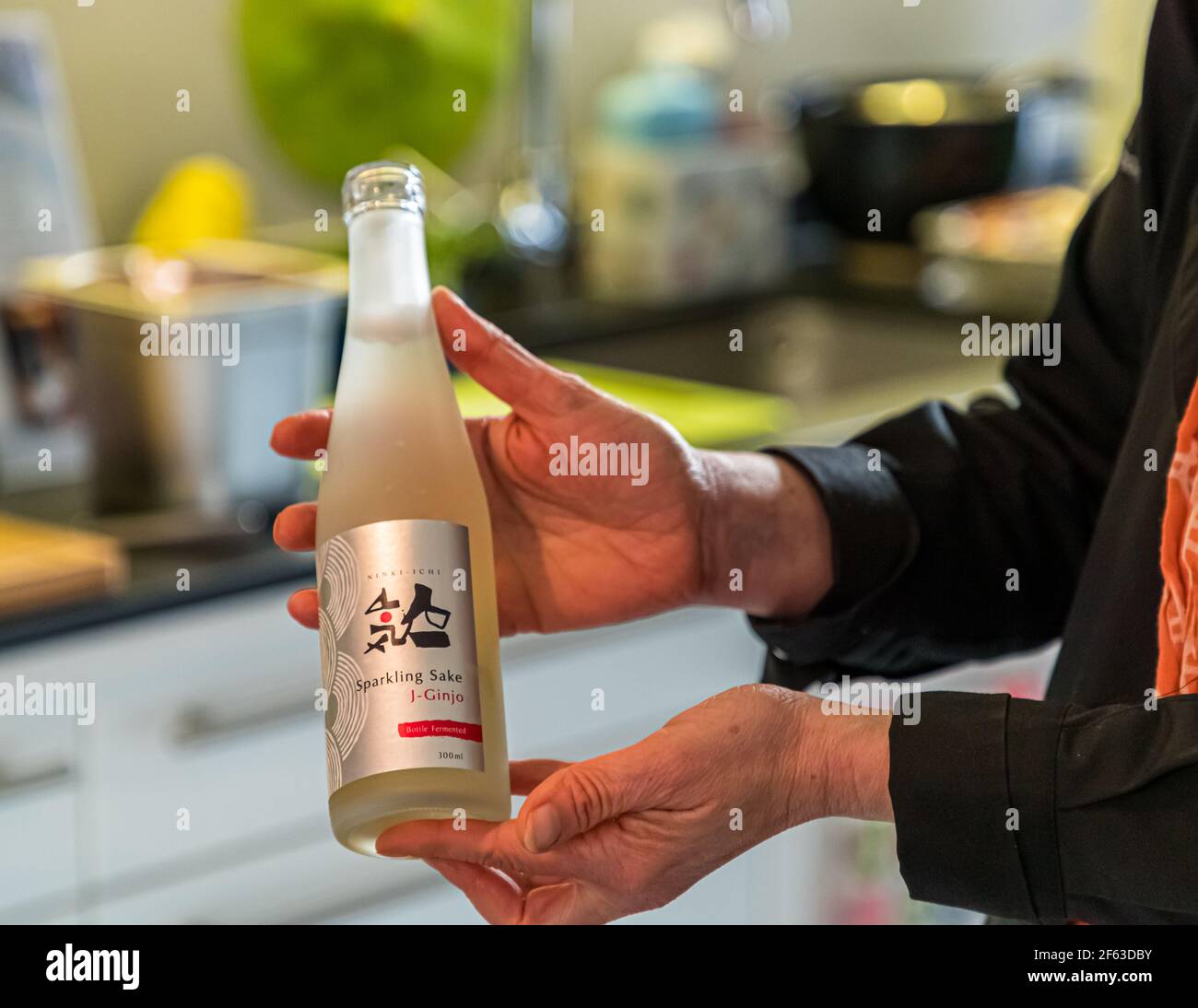 Online cooking course with the head chef Song Lee from the restaurant Nikkei Nine in Hamburg. As an aperitif, a Sparkling Sake from Ninki-Ichi. bottle fermentation with a pleasantly sweet and sour taste and low alcohol content Stock Photo