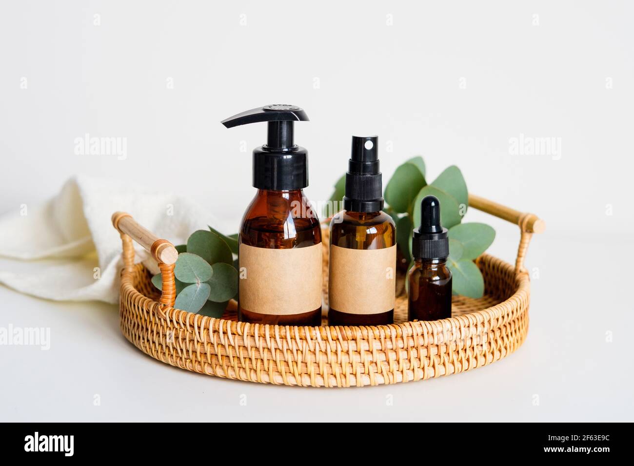 Set of eco natural organic cosmetics for personal hygiene in rattan tray. SPA beauty products design. Amber glass bottles mockups with labels. Stock Photo
