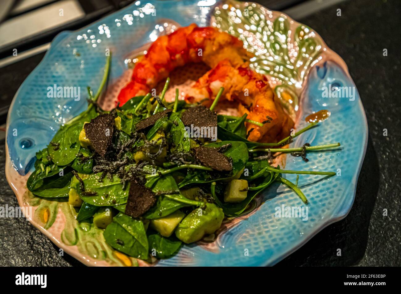 The meat of the carabineros is served together with the baby spinach salad, Avocado, white truffle sauce and grated black winter truffle. Online cooking course with the head chef Song Lee from the restaurant Nikkei Nine in Hamburg Stock Photo