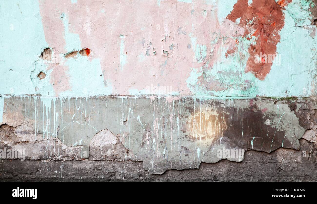 Old stone wall with paint layers, abstract urban background photo texture Stock Photo
