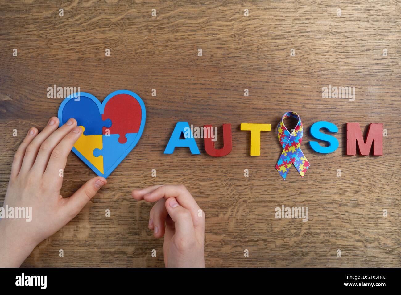 Autistic boy hands holding heart shapeed puzzle with word autism and ...