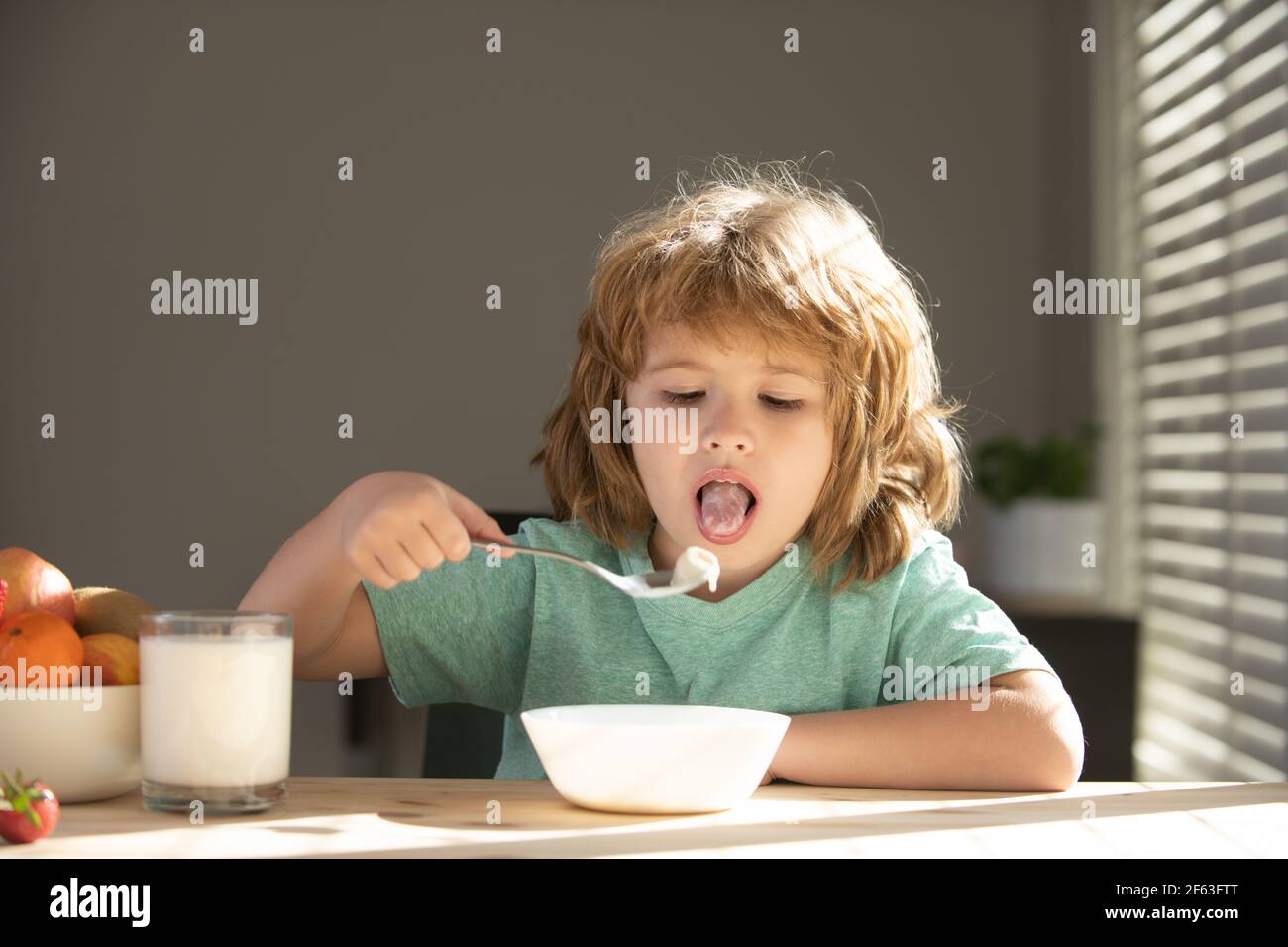 Little healthy hungry baby boy eating soup from with spoon. Child nutrition concept. Stock Photo