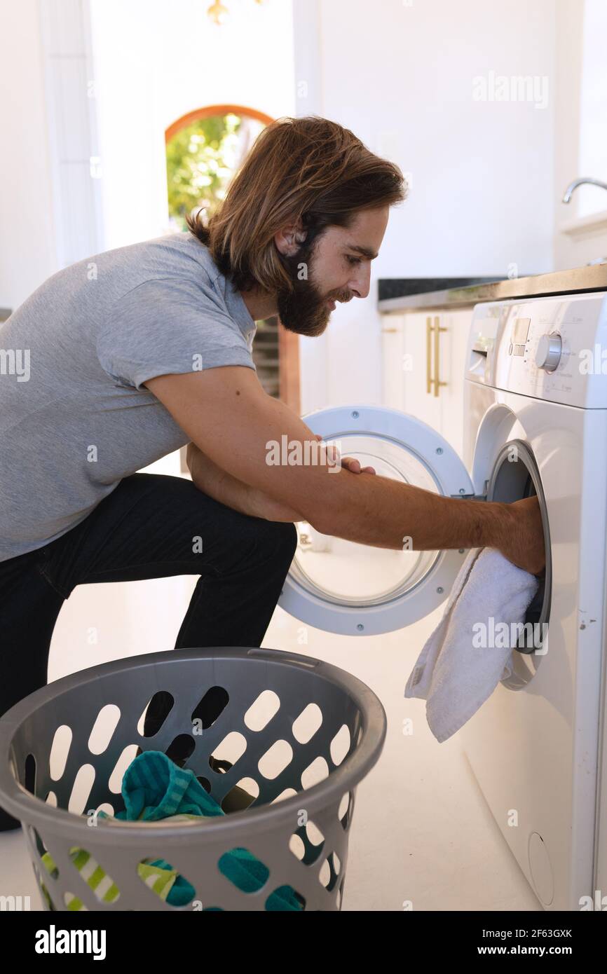 Caucasian man wearing gray tshirt and doing laundry Stock Photo