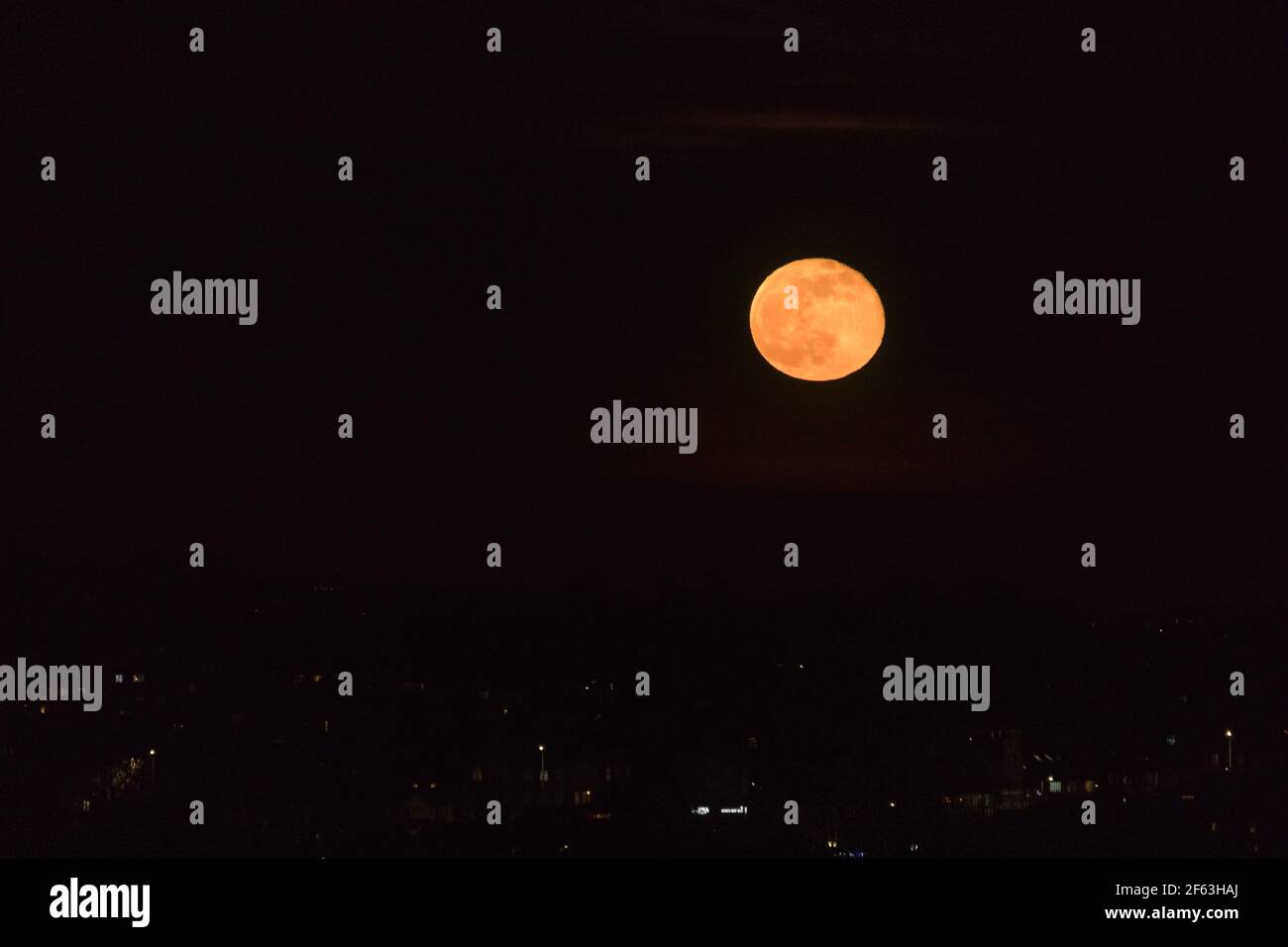 UK Moonrise, Wembley Park, UK. 29th March 2021.Stunning Waning Gibbous Moon rising a deep orange red. Amanda Rose/Alamy Live News Stock Photo