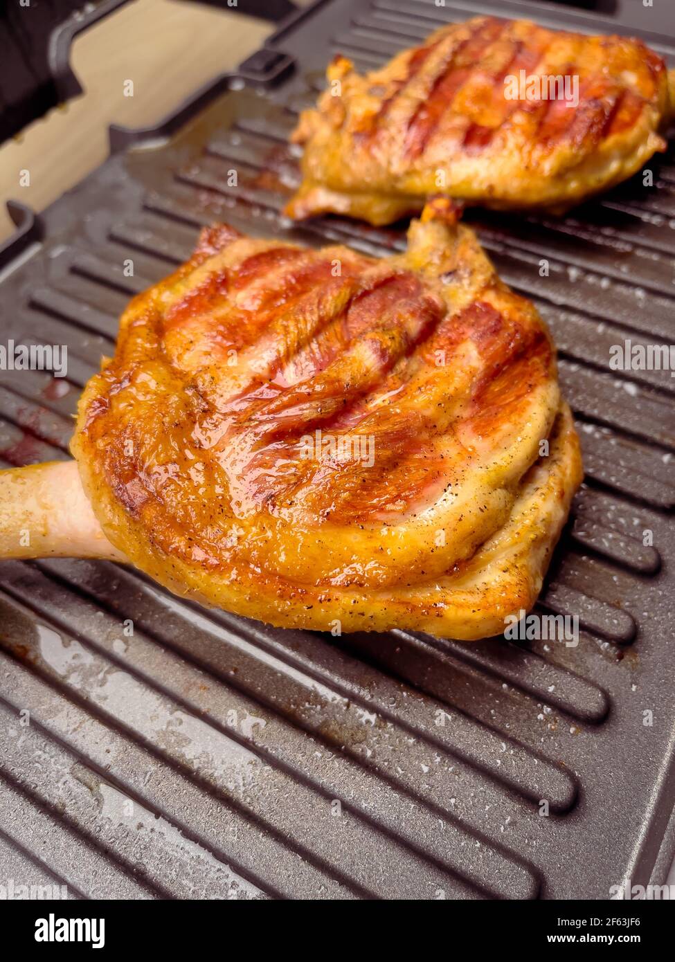 Homemade grilled duck thighs. Preparing duck meat on electric grill