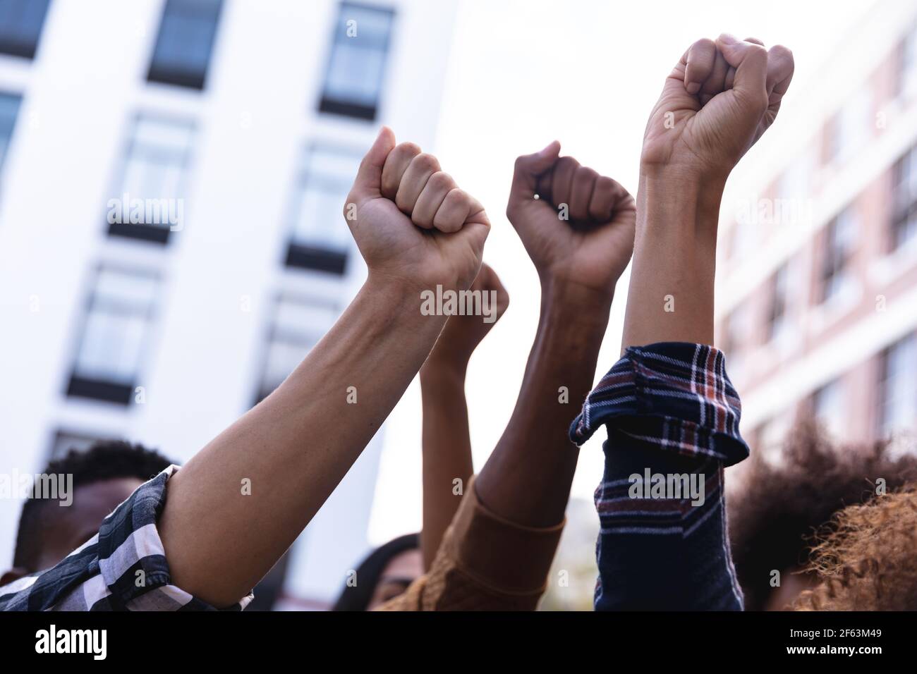 Raised fists of diverse male and female protesters demonstrating on march Stock Photo