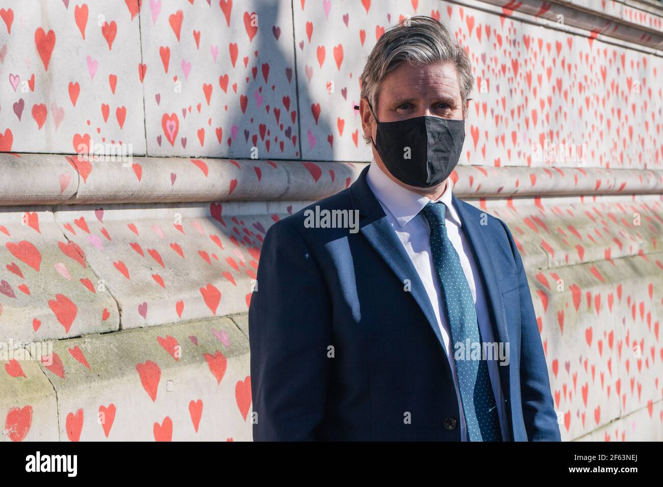 St Thomas's Hospital, London, UK. 29th March 2021. The bereaved and volunteers paint hearts for each person who has died of Covid. sir Keir Starmer, leader of the Labour Party pays a visit to the wall to see the work in progress and talk to the volunteers. Credit: Denise Laura Baker/Alamy Live News Stock Photo