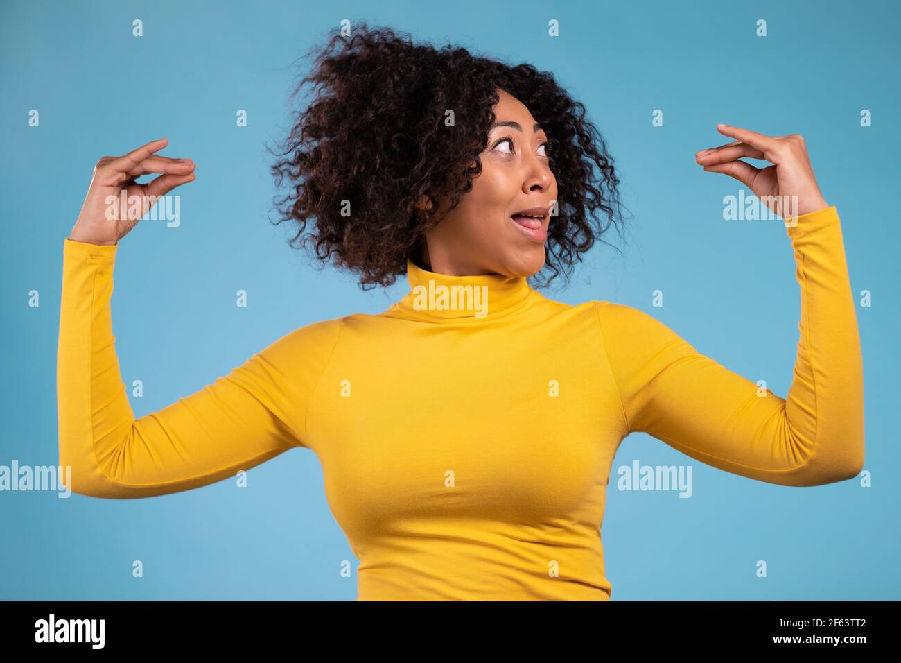 Pretty african woman showing bla-bla-bla gesture with hands isolated on blue background. Empty promises, blah concept. Lier. Stock Photo
