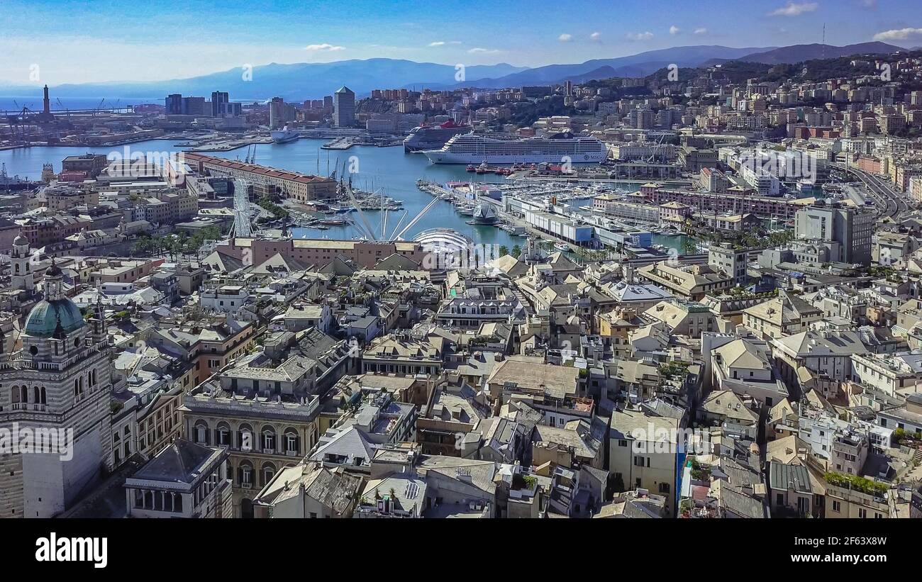 Aerial panoramic drone view of buildings and streets surrounding Port of Genoa.Cruise ships and ferries in port.Old famous city of Italy, with beautif Stock Photo