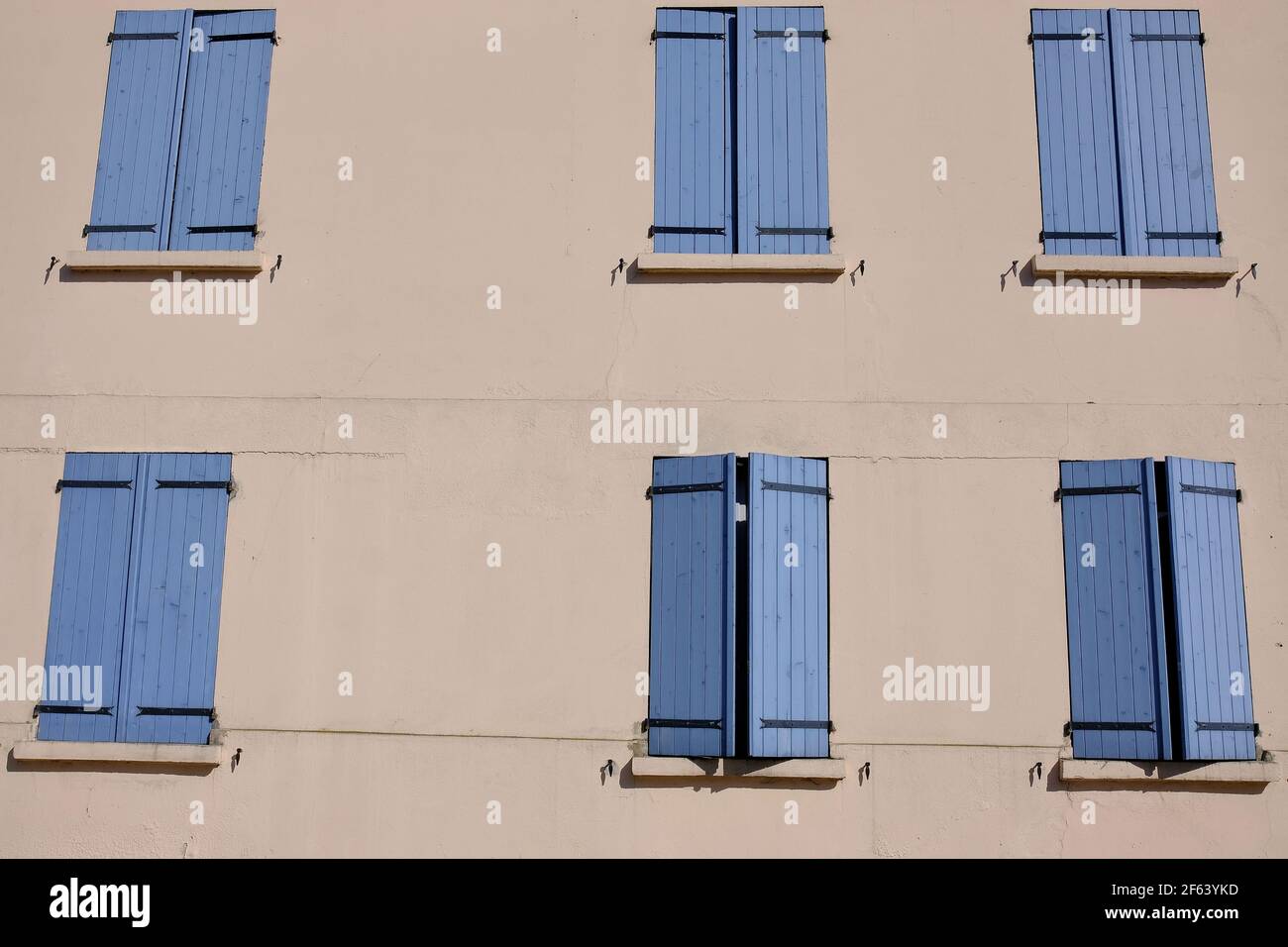A residential building with blue window shutters in a small village in