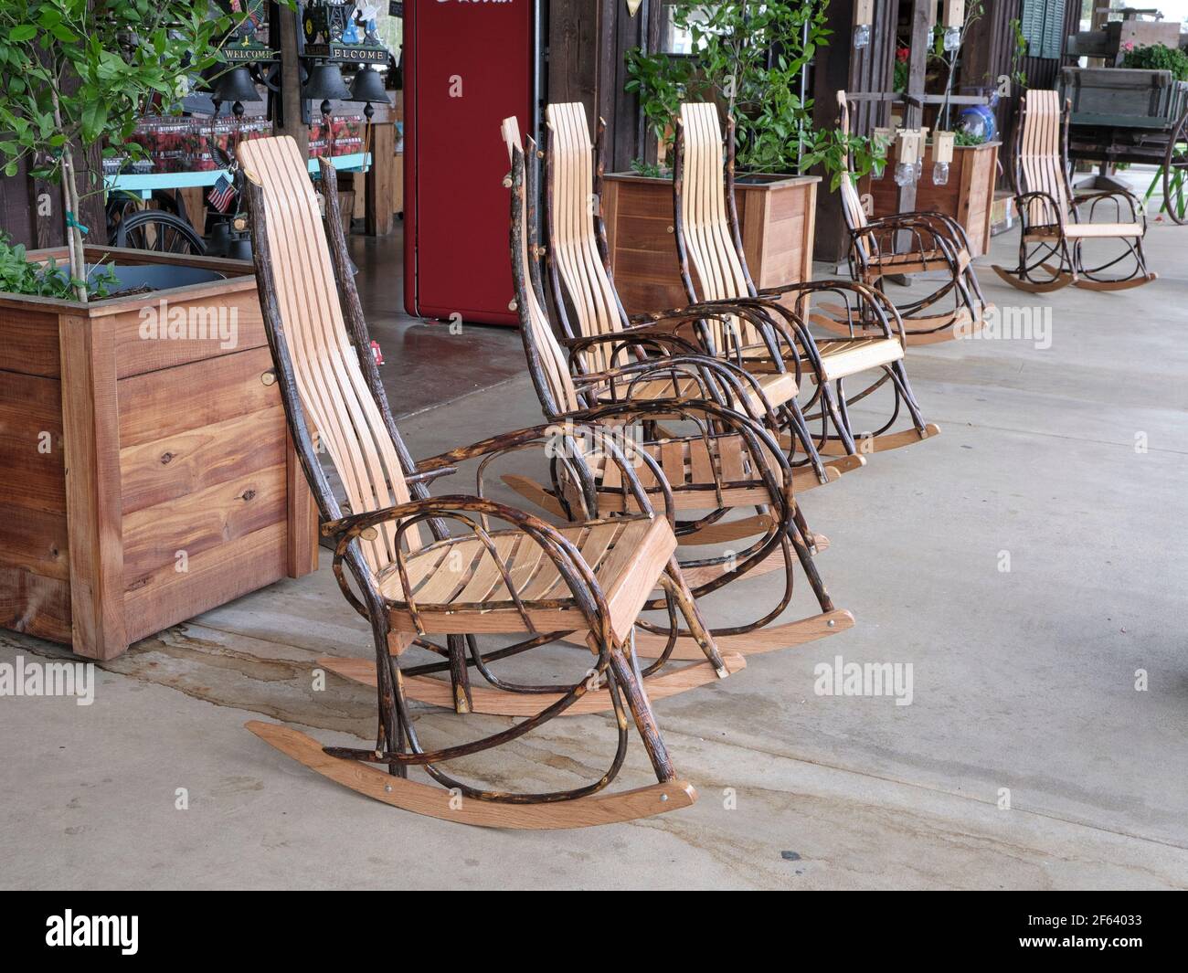 Wooden rocking chairs for sale lined up in a row on display at a country store in Pike Road Alabama, USA. Stock Photo