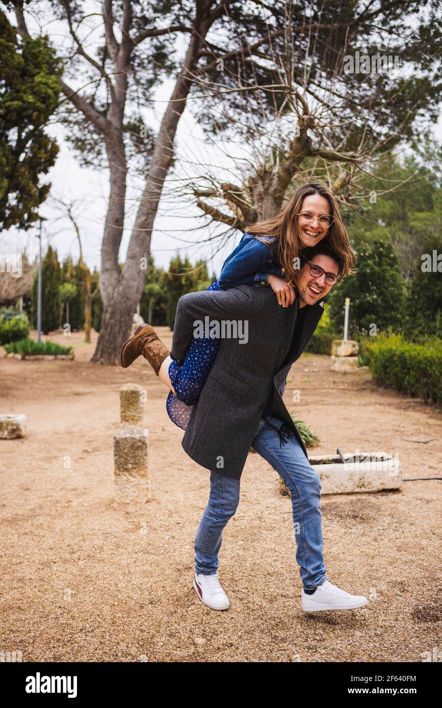Young girl climb on the back of her boyfriend, piggyback, having fun