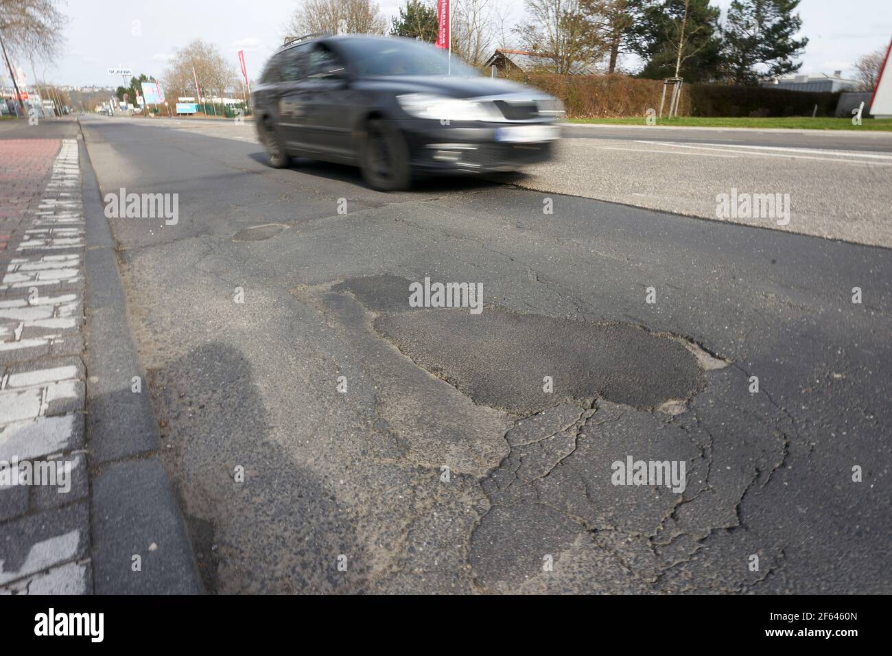 Koblenz, Germany. 28th Mar, 2021. A partially repaired pothole on  August-Horch-Strasse in the industrial area. The ADAC Mittelrhein warns  that the substance of the municipal traffic infrastructure has been  deteriorating for many