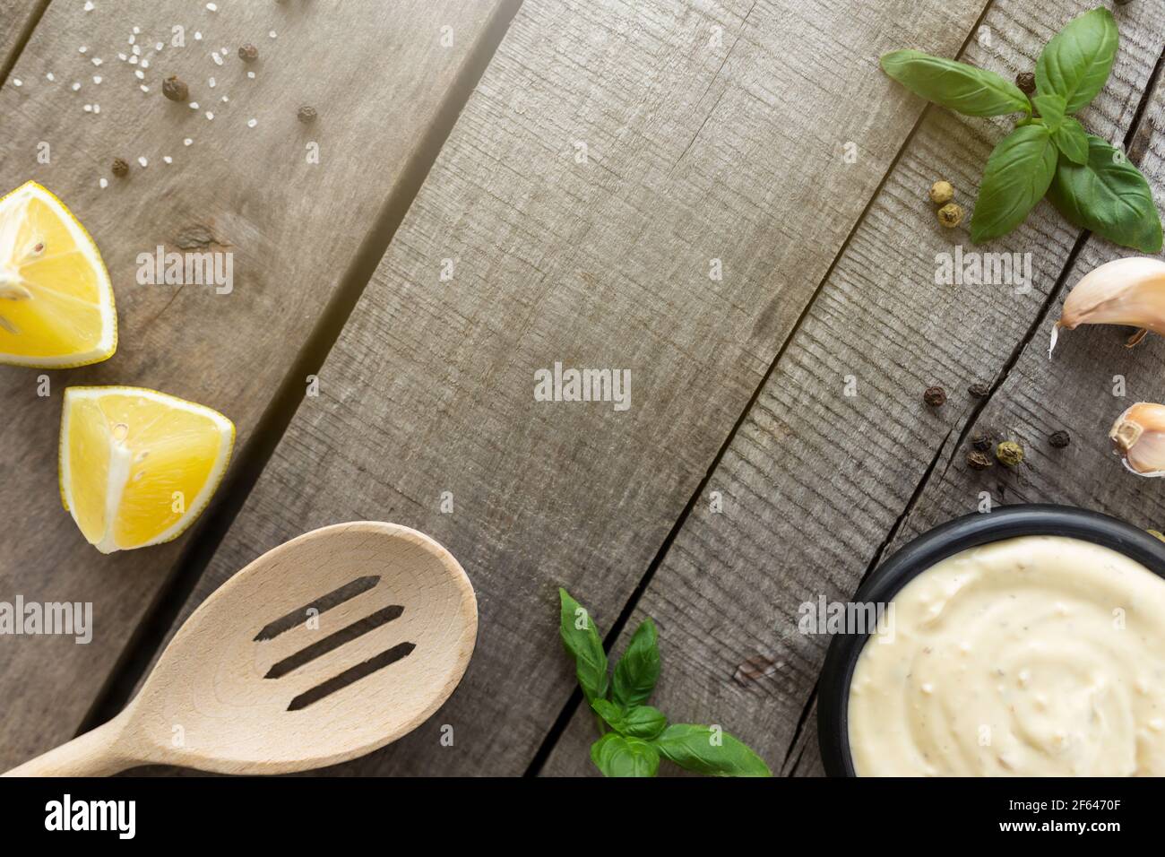 Conceptual flat lay. Making garlic cream sauce or cooking cheese sauce, mayonnaise, mustard, food and seasoning on wooden background. High quality pho Stock Photo